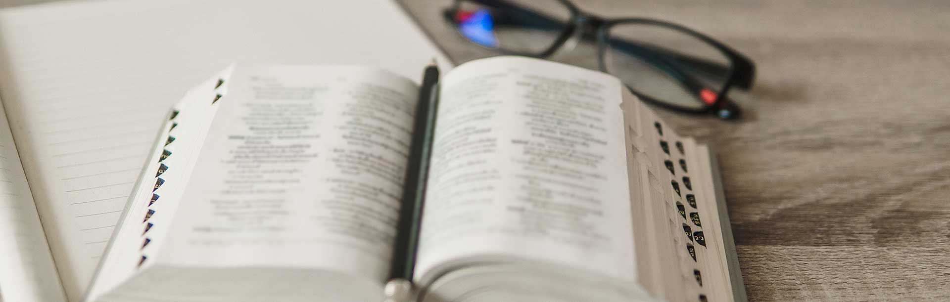 open bible on table with glasses